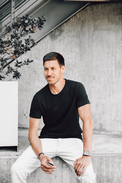 Man in black t-shirt against wall